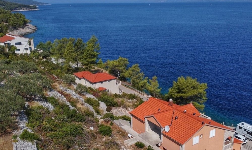 Maisons aux toits de tuiles sur la rive boisée vues d'en haut