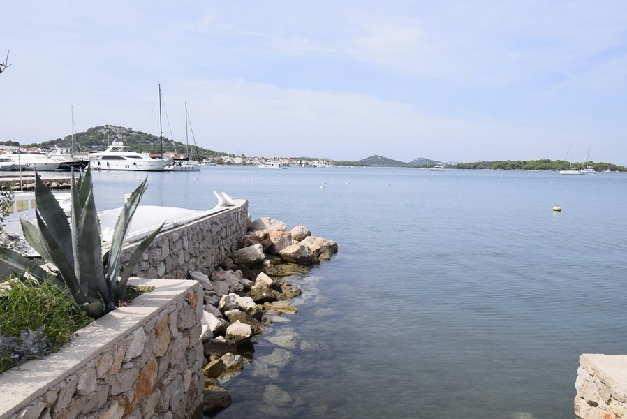 Agaves au mur du quai avec bateaux dans la baie