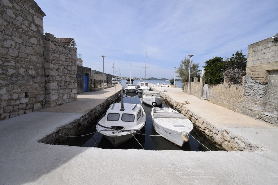 La maison comprend un petit bateau avec moteur hors-bord.