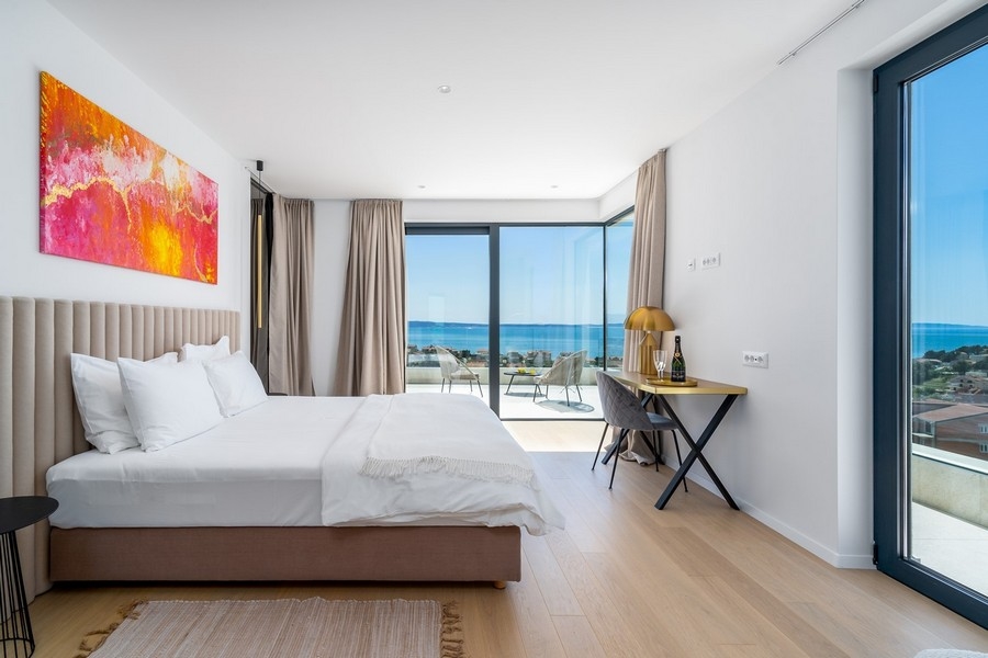 Chambre avec grandes baies vitrées et vue mer