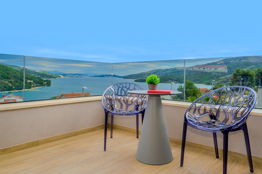 Balcon avec deux chaises design et vue sur la baie