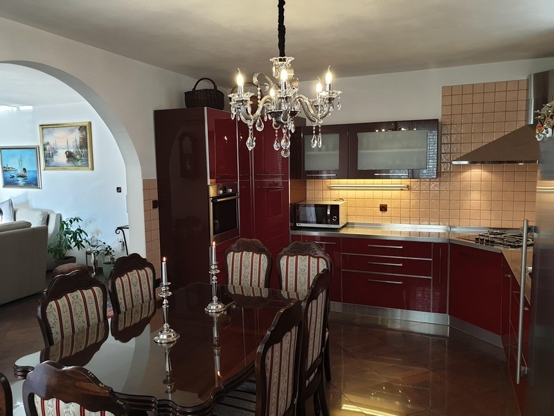 Élégante salle à manger avec cuisine brun-rouge dans une maison à plusieurs logements en Croatie