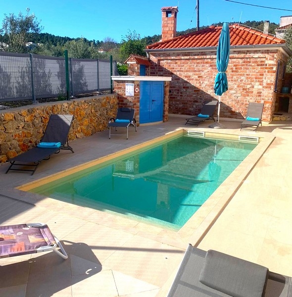 Espace piscine d'une maison en pierre en Croatie, idéal pour des journées de détente en plein air