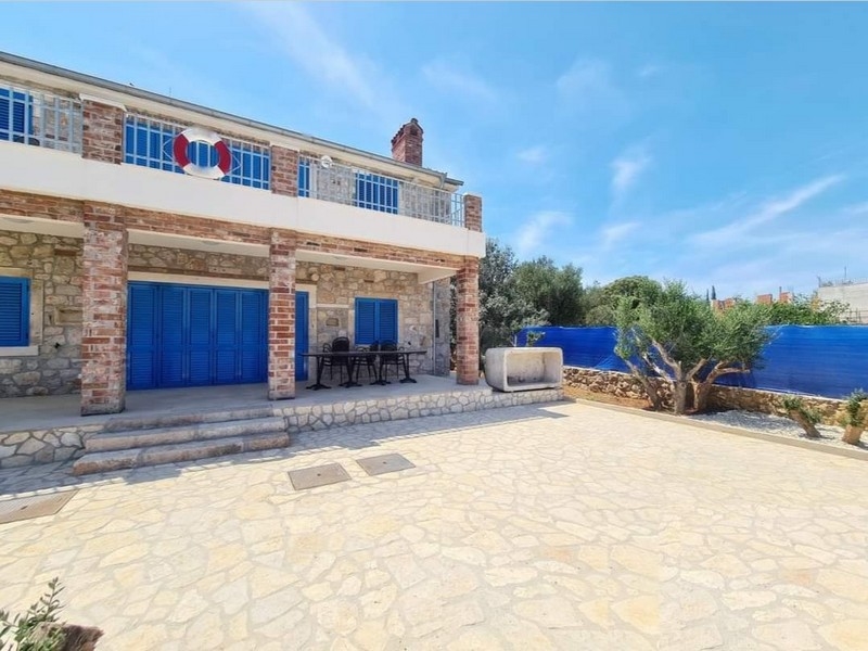 Façade d'une charmante maison en pierre à vendre en Croatie avec coin repas extérieur.