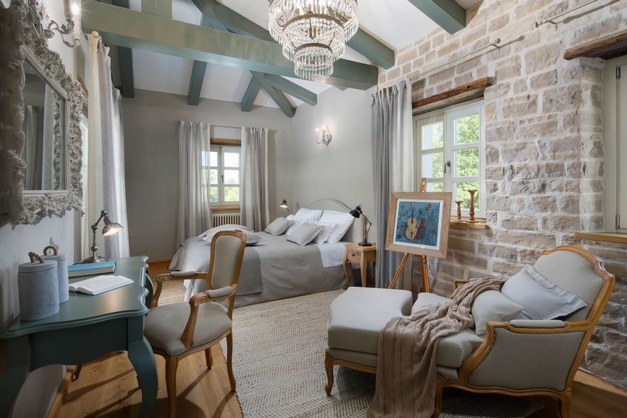 Chambre avec mur en pierre et lustre dans une villa en Istrie