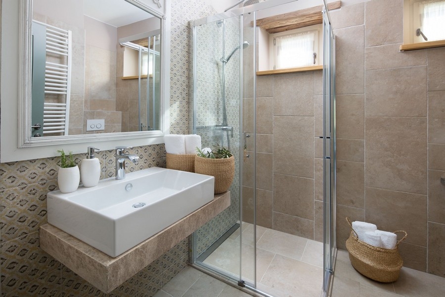 Salle de bains avec baignoire blanche et douche dans une villa
