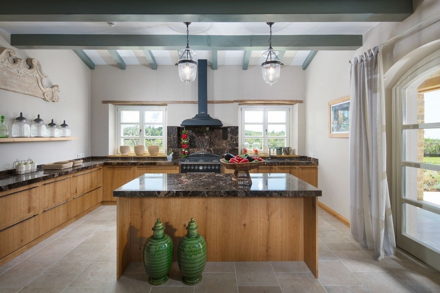 Cuisine de style campagnard avec poutres en bois et îlot de cuisson dans une villa en Istrie