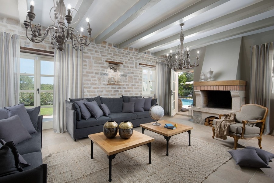 Spacieux salon avec canapés confortables, cheminée et décor rustique en Croatie.