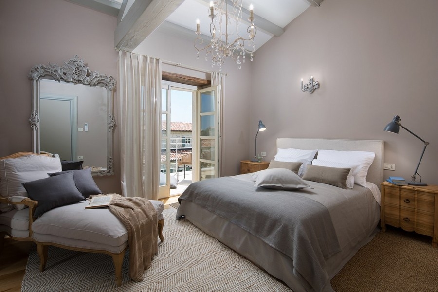 Chambre aménagée avec goût, avec grand lit et miroir dans une villa en Croatie.