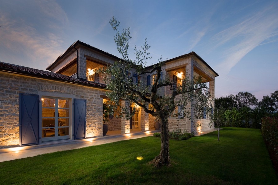 Villa avec façade en pierre éclairée et volets bleus à Kanfanar
