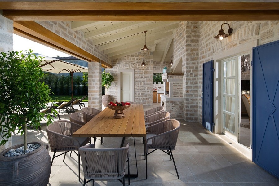 Espace extérieur couvert avec table en bois et chaises dans la villa