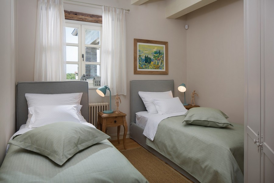 Chambre avec deux lits simples et linge de lit vert