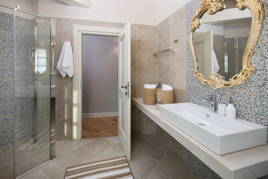Salle de bains moderne avec cabine de douche en verre et miroir dans la villa