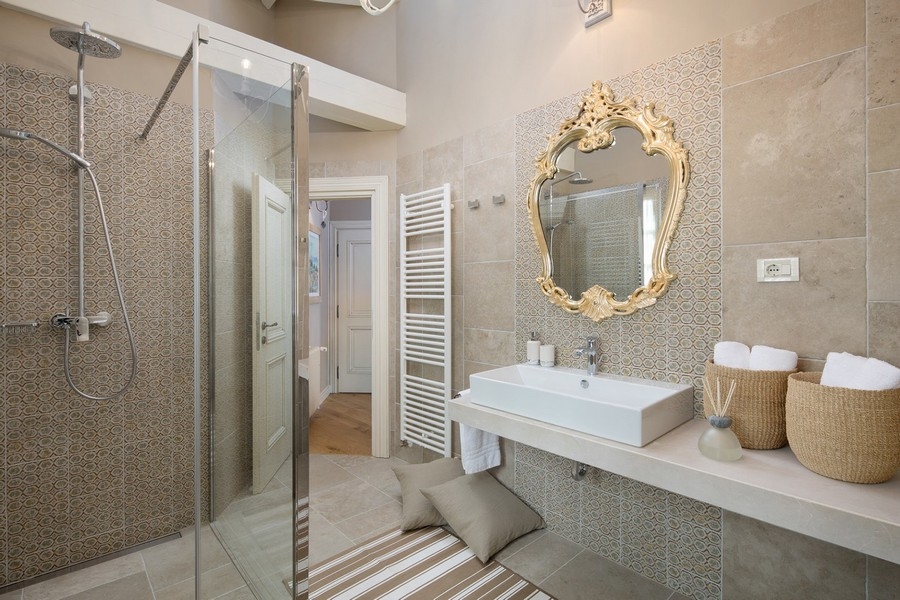 Salle de bains élégante avec douche à l'italienne, carreaux de mosaïque et banc - Immobilier Croatie
