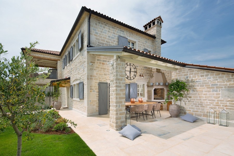 Patio extérieur avec espace repas et cheminée maçonnée dans la villa