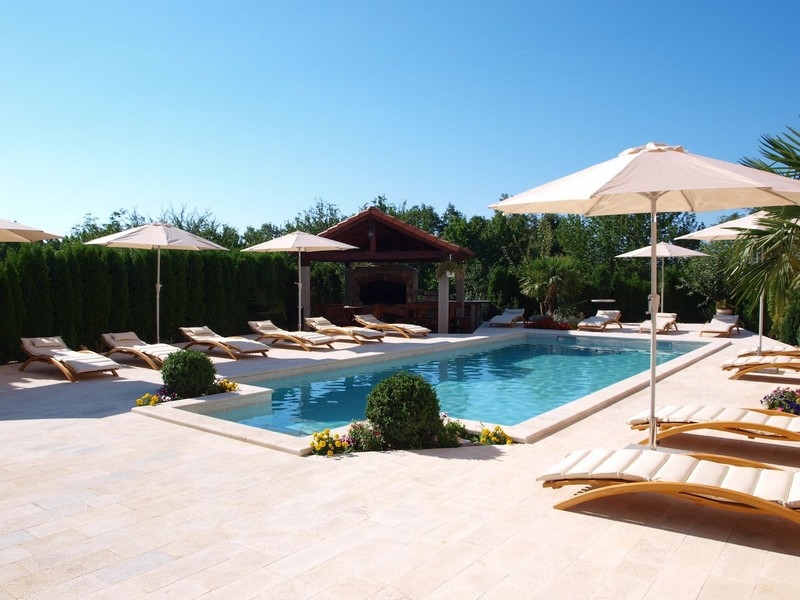 Élégante piscine avec bains de soleil près d'un bien croate