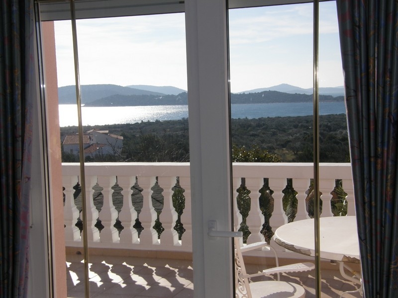 Vue mer depuis la terrasse de la villa croate à travers des garde-corps blancs