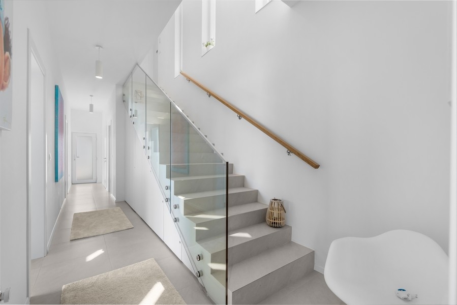 Cage d'escalier au design moderne avec garde-corps en verre dans une villa en Istrie, commercialisée par Panorama Scouting