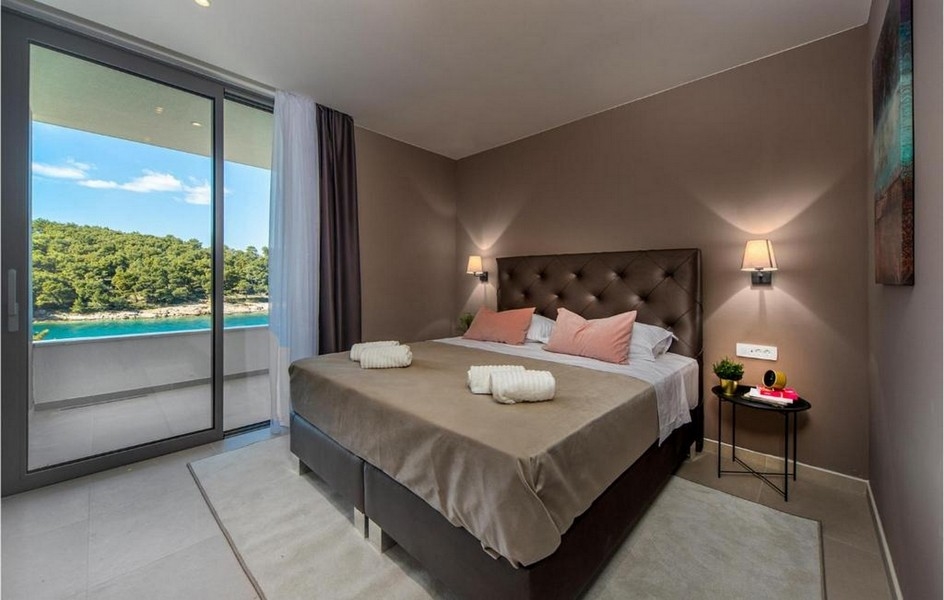 Chambre avec lit double, design moderne et vue mer dans la villa sur Brac.
