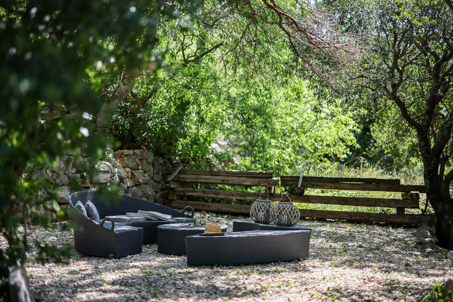 Espace lounge extérieur ombragé dans le jardin d'une maison en pierre croate