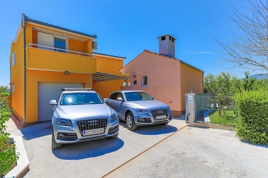 Allée d'accès avant avec deux voitures garées devant l'immeuble de rapport à Kaštel Lukšić, Croatie