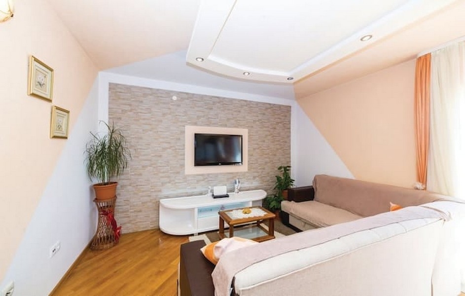 Salon avec canapé et télévision dans l'immeuble de rapport à vendre à Kaštel Lukšić, Croatie