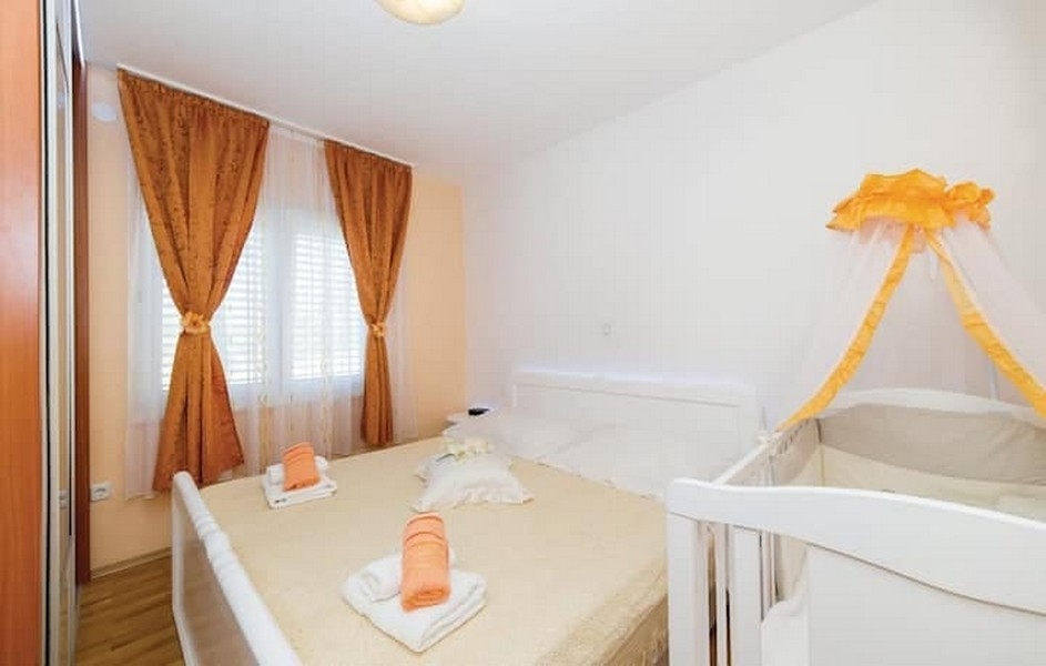 Chambre avec lit double et lit bébé dans l'immeuble de rapport à Kaštel Lukšić, Croatie