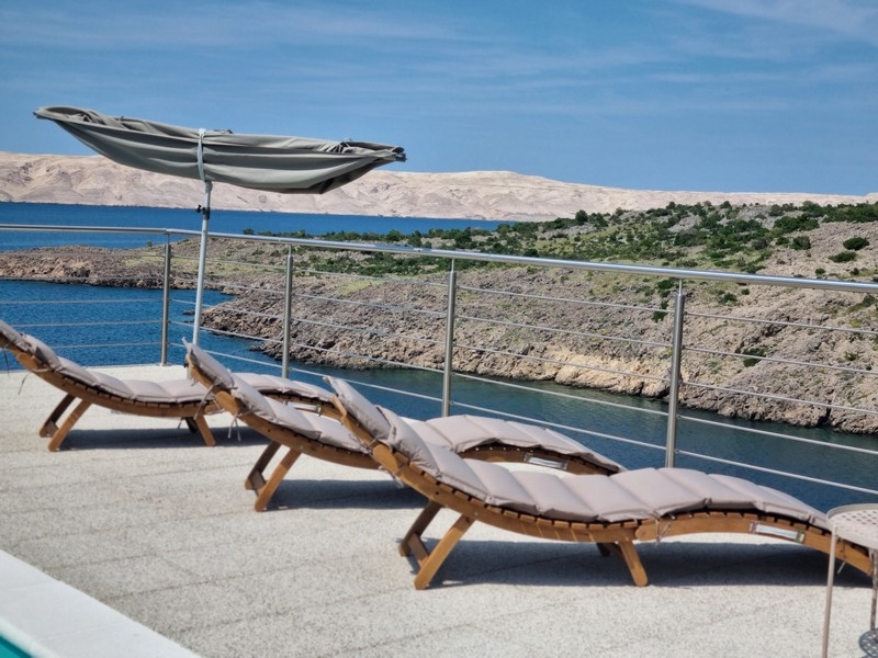 Chaises longues avec parasol et vue mer sur la terrasse