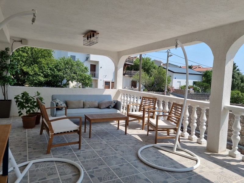Terrasse couverte avec mobilier de salon et vue mer