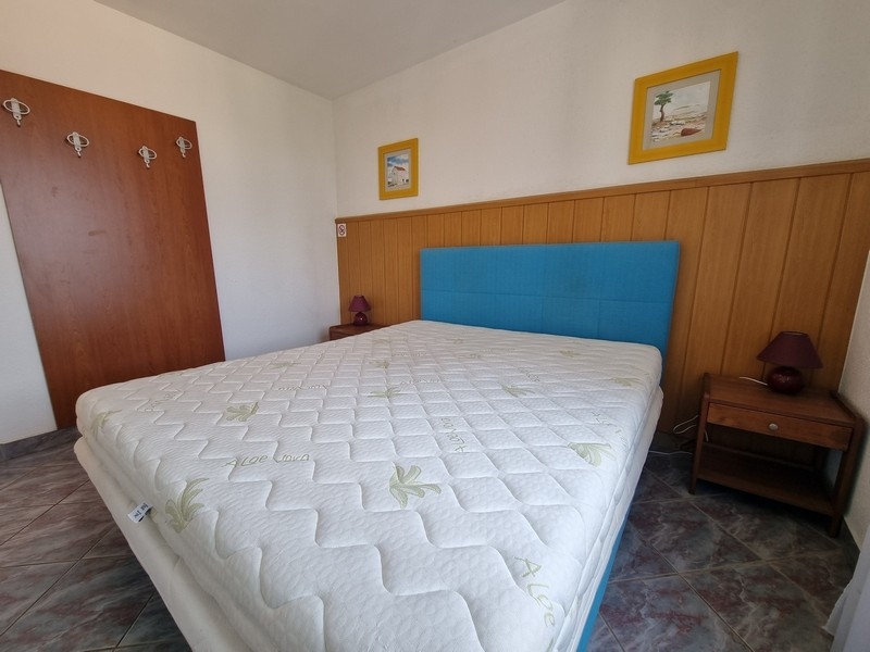 Chambre avec tête de lit bleue et lambris en bois