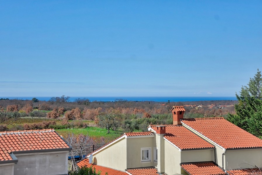 Vue sur la mer et les toits environnants depuis la terrasse supérieure de la maison jumelée neuve en Istrie