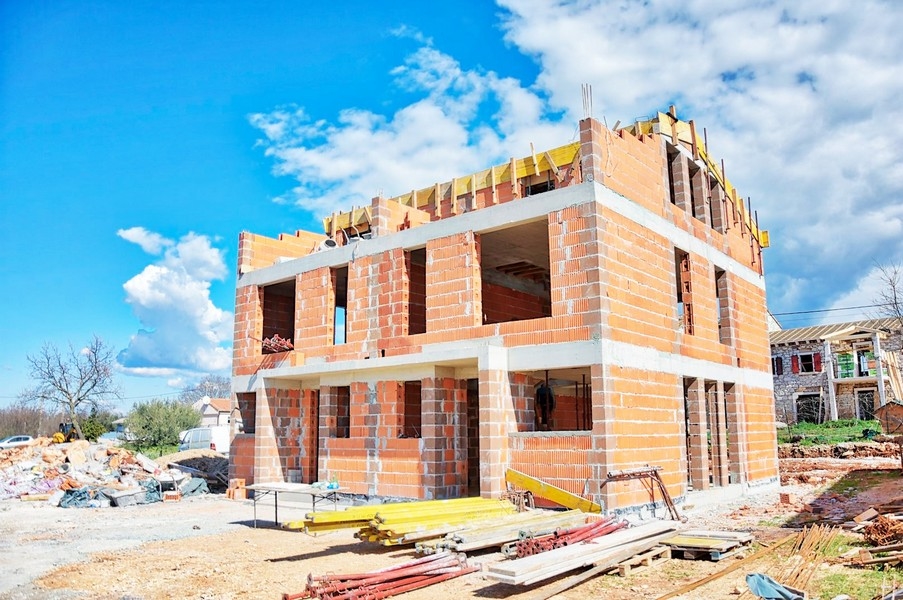 Gros œuvre de la maison jumelée en phase de construction avec briques et échafaudage