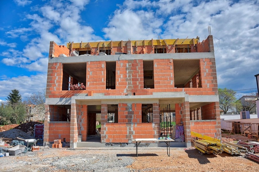 Gros œuvre de la maison jumelée, perspective latérale, pendant la construction