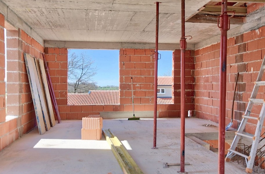 Vue intérieure de la maison jumelée en construction avec vue vers l'extérieur par une grande ouverture