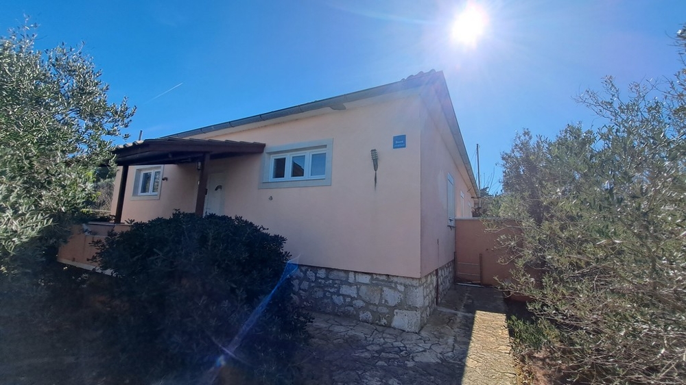 Vue sur le côté d'une maison entourée de plantes méditerranéennes, bien en bord de mer en Croatie