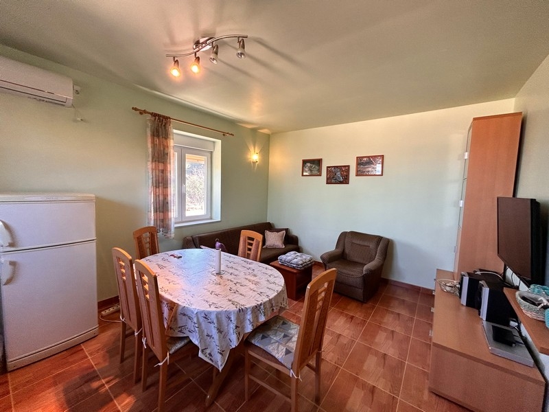 Séjour avec table à manger et équipement de cuisine, intérieur d'un bien en bord de mer en Croatie