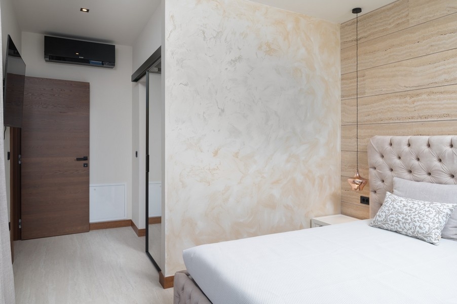 Chambre au design moderne avec tête de lit capitonnée dans une villa à vendre à Razanac, région de Zadar, Croatie, avec porte coulissante vers le couloir