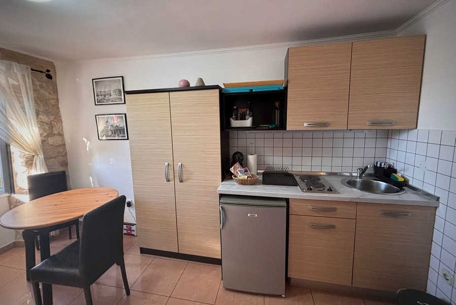 Vue intérieure d'une petite cuisine d'un bien en Croatie avec table et placards intégrés