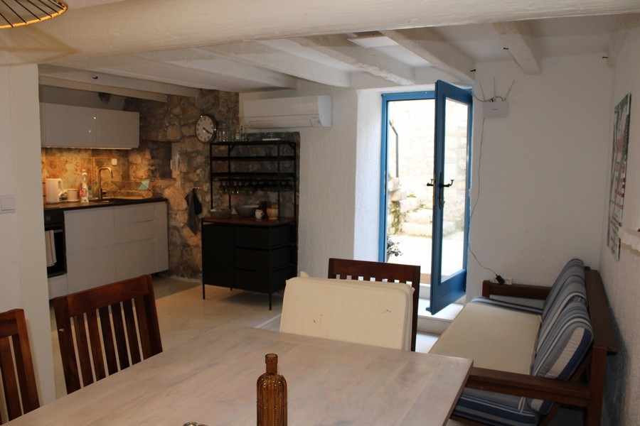Vue intérieure de la maison en pierre à Murter, séjour et coin repas.