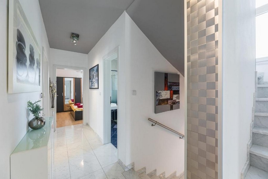 Entrée et couloir d'un immeuble collectif en Croatie avec vue mer, avec carrelage brillant au sol, cage d'escalier et décoration murale