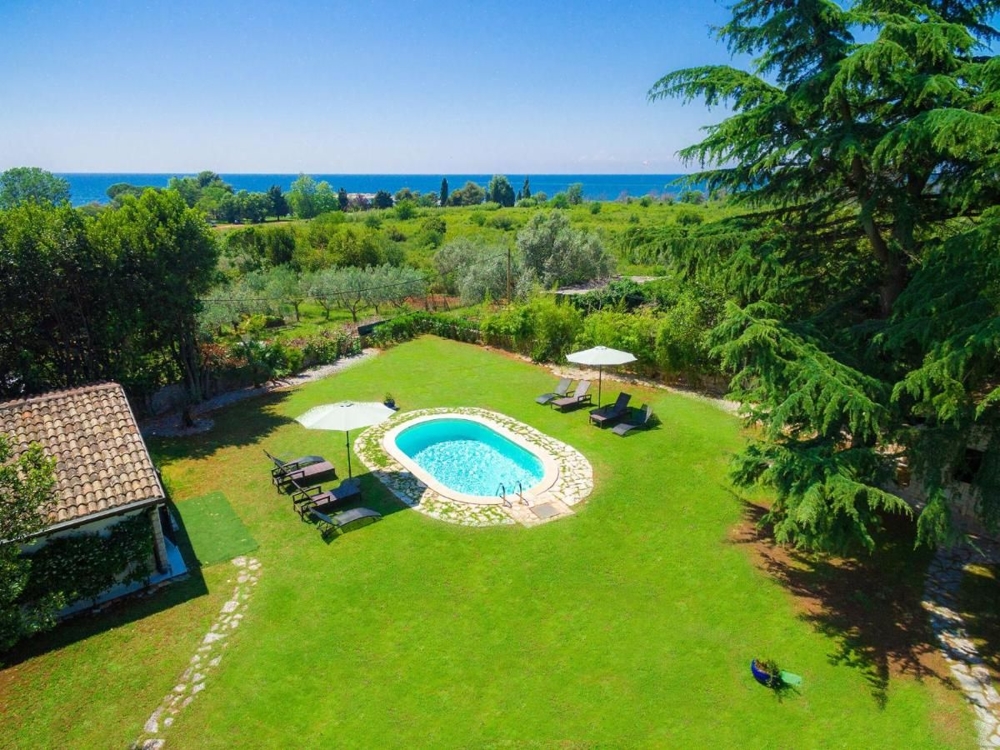 Vue aérienne d'un jardin verdoyant avec une piscine en forme de cœur, idéale pour des biens immobiliers en Croatie