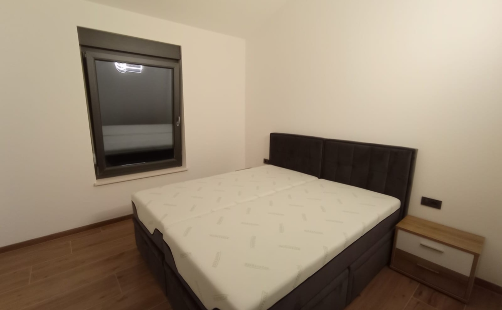 Chambre sobre avec lit double dans un bien en Croatie, fenêtre de nuit fermée.