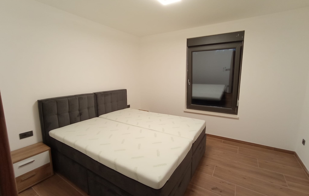 Perspective similaire de la chambre d'un bien en Croatie, avec table de chevet et fenêtre fermée.