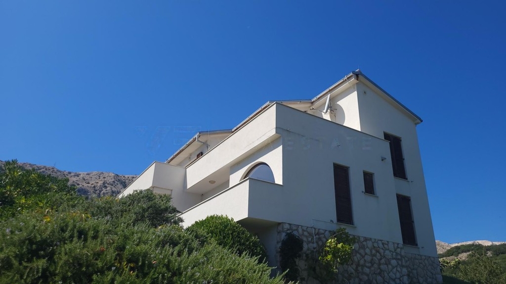 Façade blanche de la maison avec balcons à flanc de colline