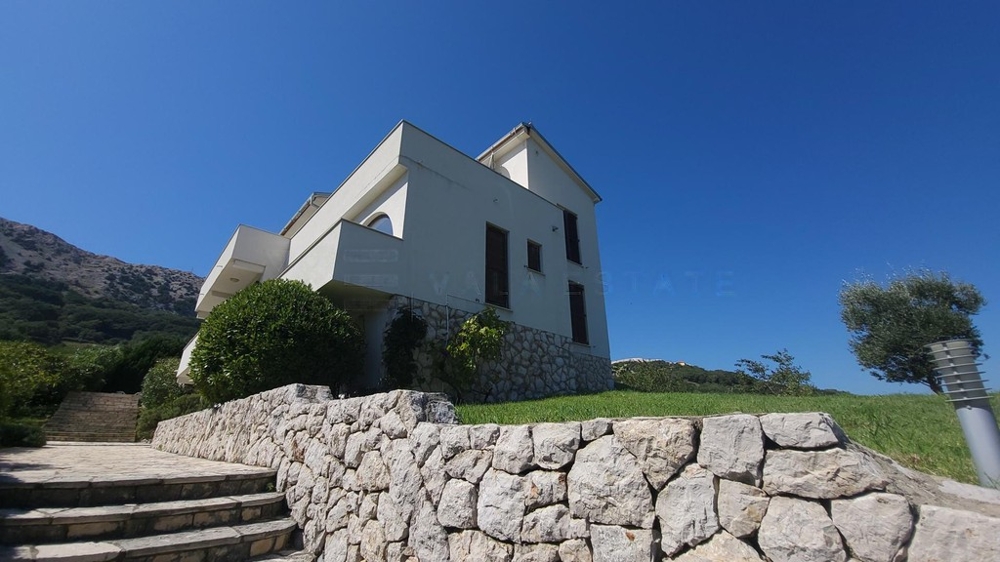 Maison avec mur en pierre naturelle, pelouse et escalier