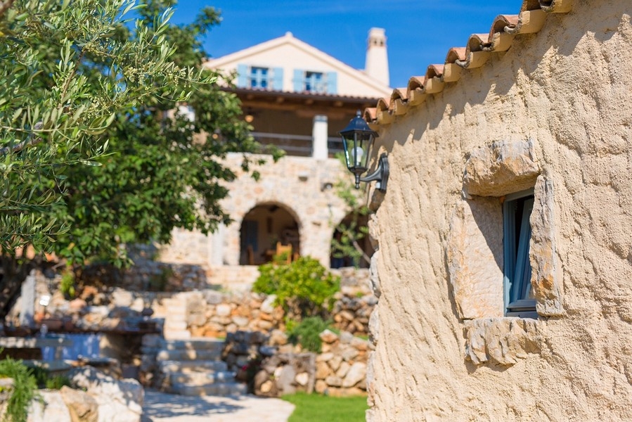 Vue sur la façade en pierre de la villa, encadrée de verdure méditerranéenne, caractérise le bien sur l'île de Krk.