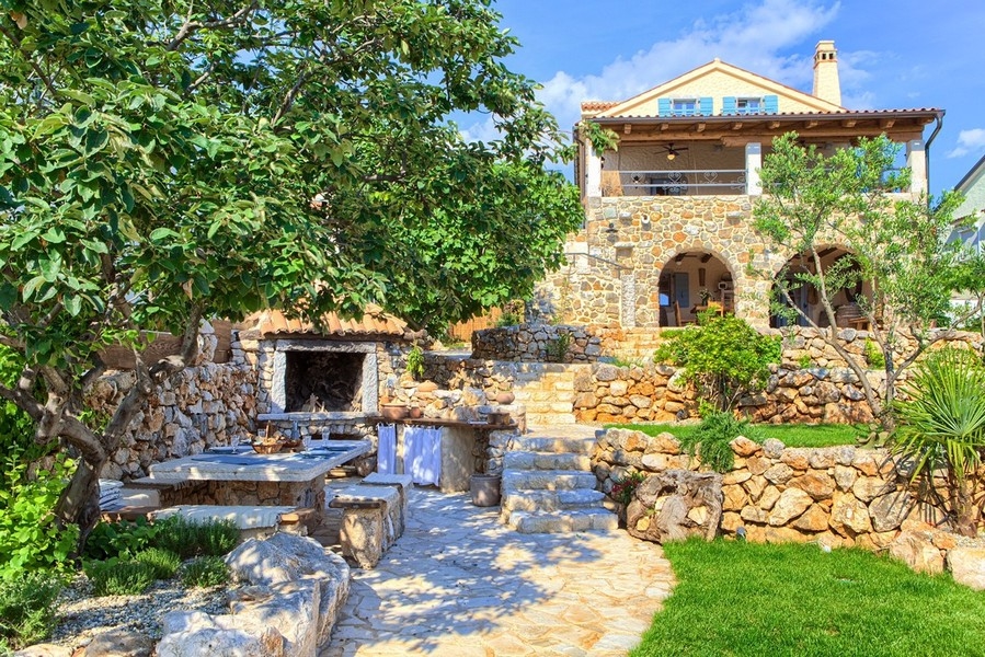 Coin barbecue maçonné en plein air avec places assises, idéal pour des soirées conviviales au bien sur l'île de Krk.