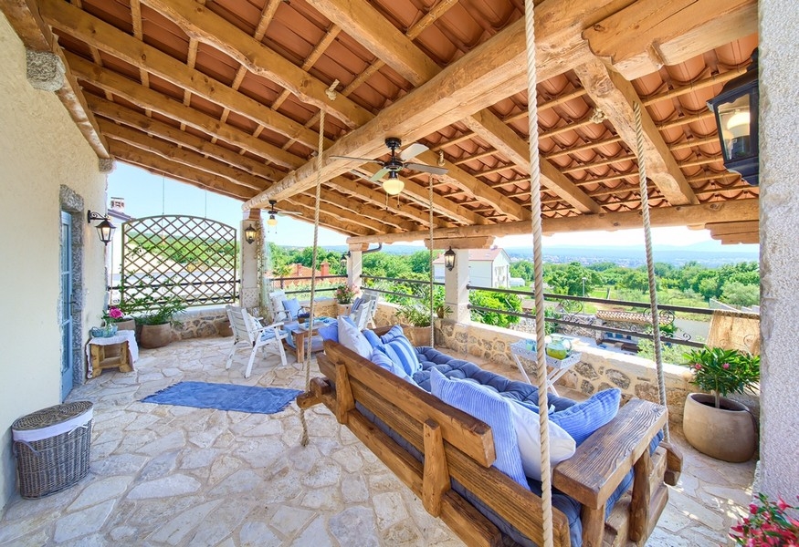 Canapé suspendu sur la terrasse en pierre, un élément de détente du bien sur l'île de Krk.