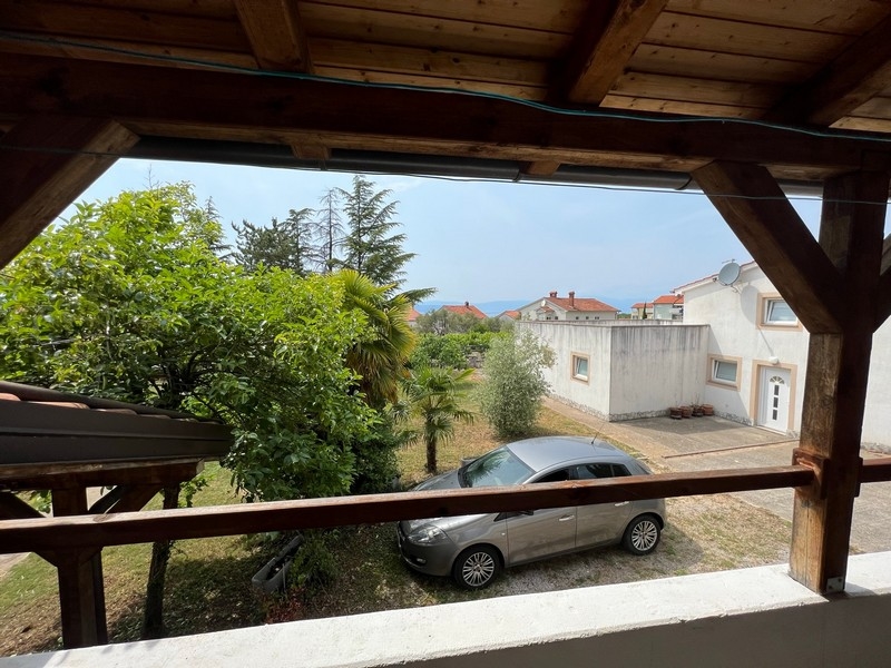 Vue depuis un balcon, entouré d'arbres verts, sur des immeubles d'habitation dans un bien sur l'île de Krk.
