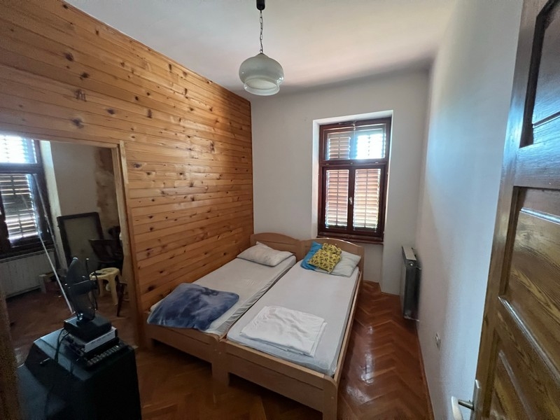 Chambre agréable aux murs en bois et deux lits simples dans un bien sur l'île de Krk.